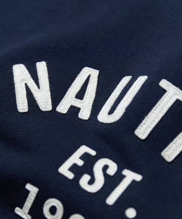 「NAUTICA/ノーティカ」から象徴的なフェルトアーチロゴを配置した”Felt Patch Arch Logo Crewneck Sweatshirt”が発売！