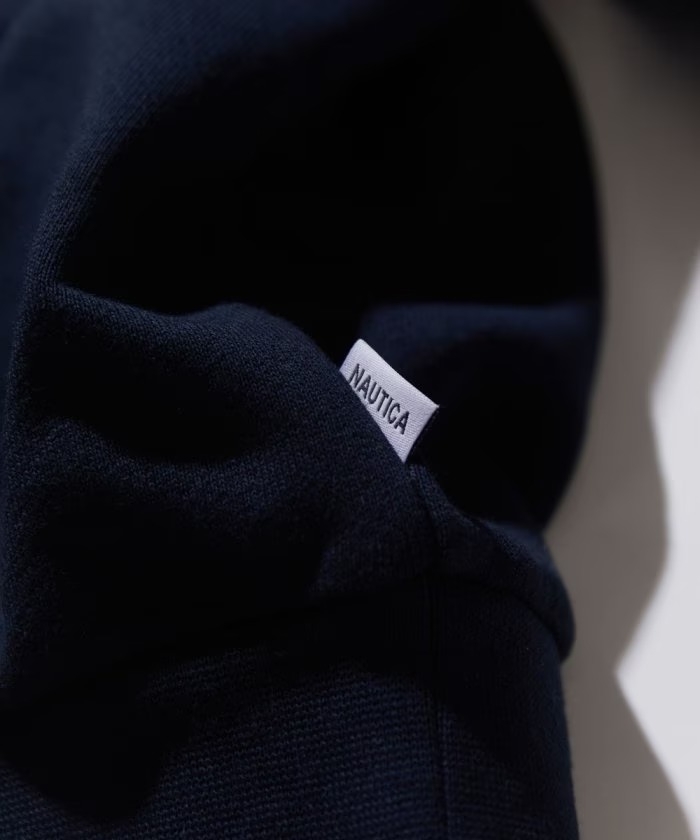 「NAUTICA/ノーティカ」から象徴的なフェルトアーチロゴを配置した”Felt Patch Arch Logo Crewneck Sweatshirt”が発売！